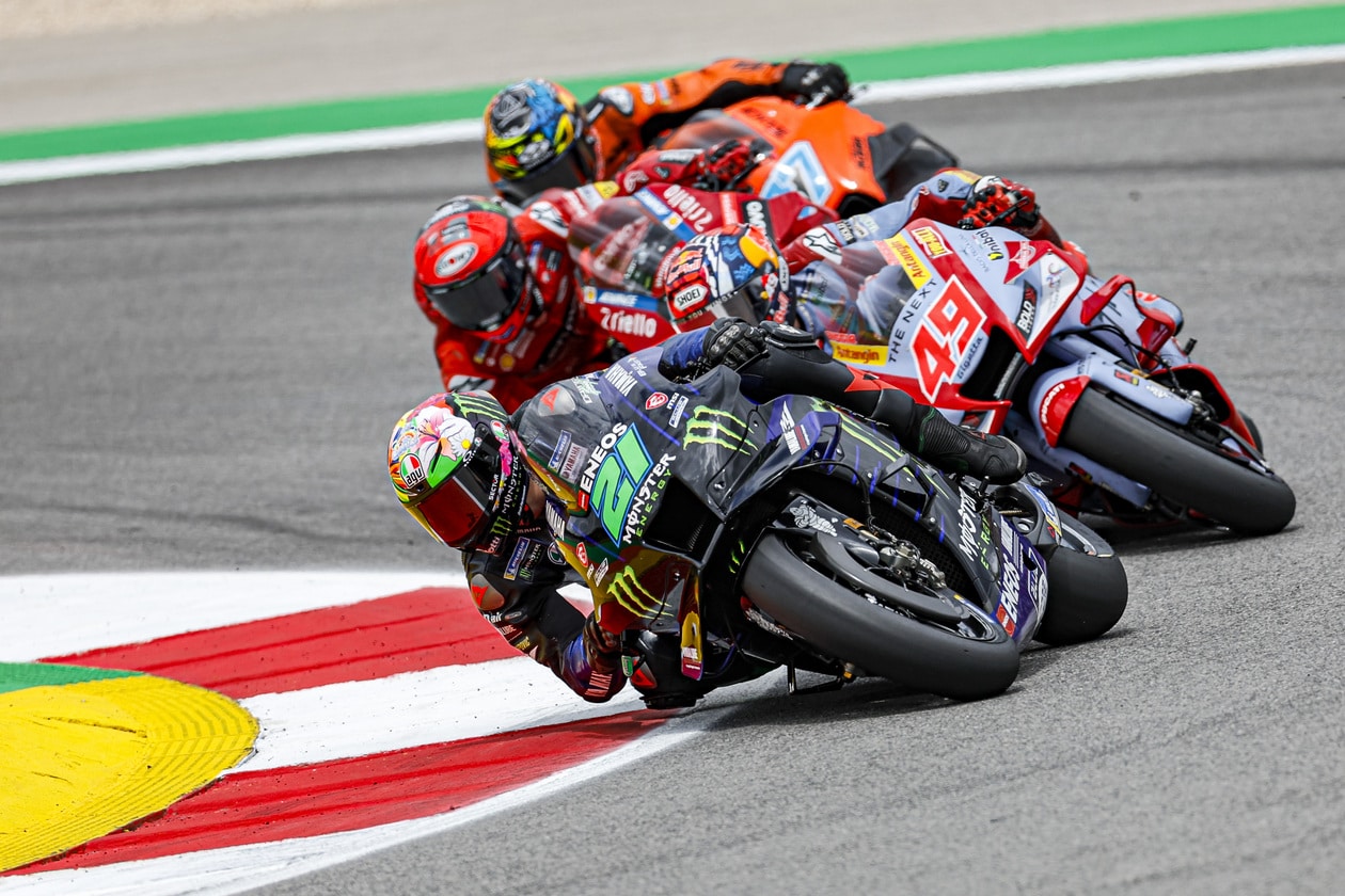 Three MotoGP racers making a turn on the track