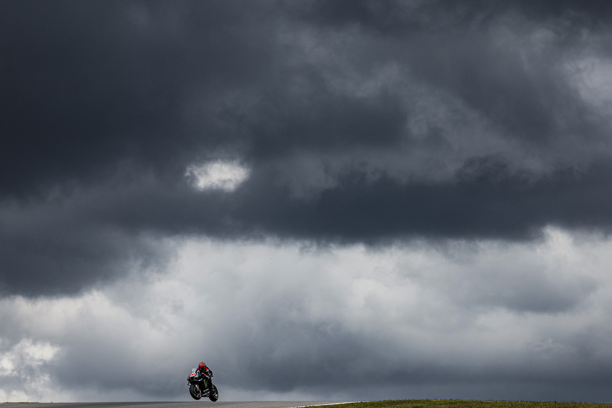 MotoGP racer with dark clouds behind them