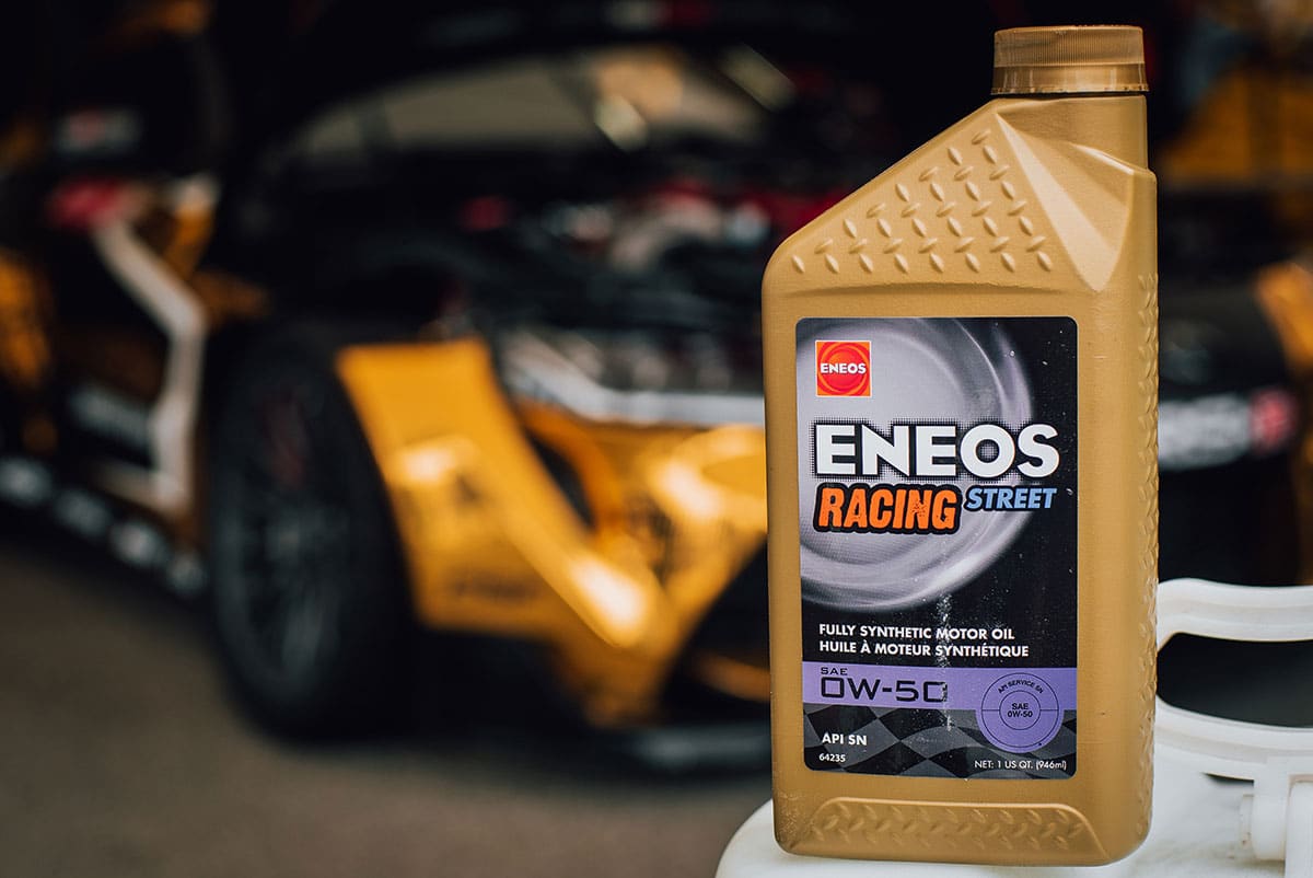 ENEOS Racing street OW-50 oil with car behind it ENEOS Racing street OW-50 oil with car behind it