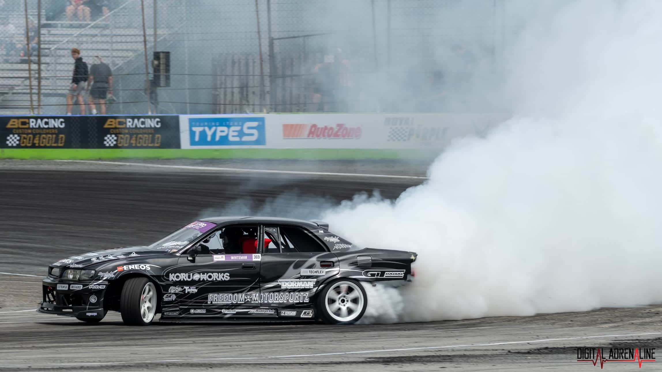 Black car drifting on a turn on race track