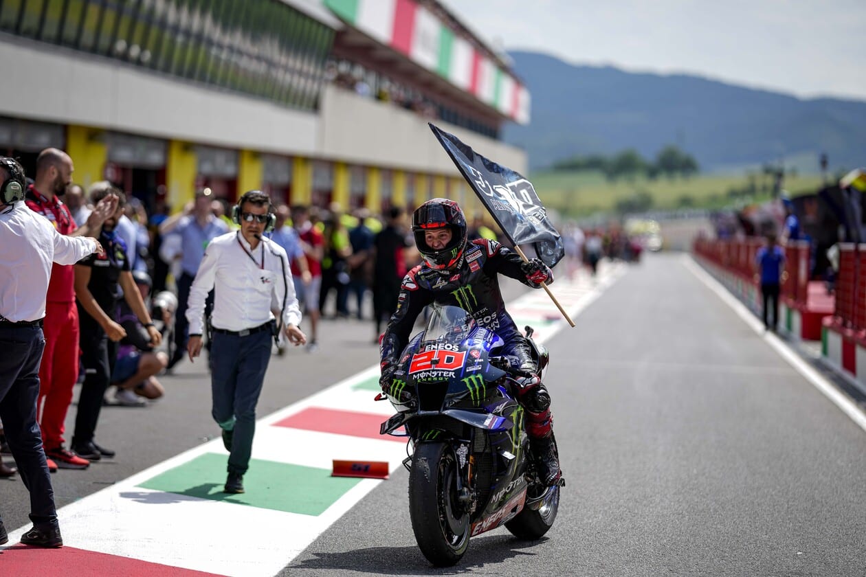 Racer holding flag while on motorcycle