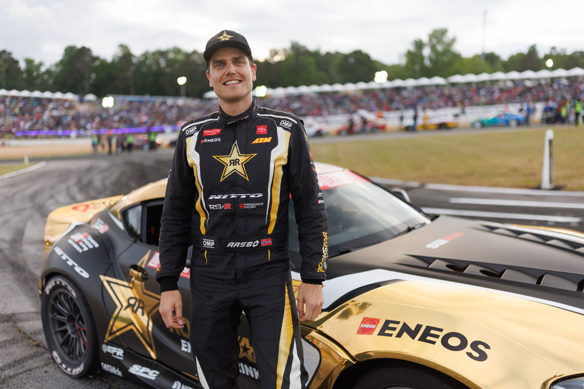 Formula Drift driver in from of Rockstar energy drink ENEOS car
