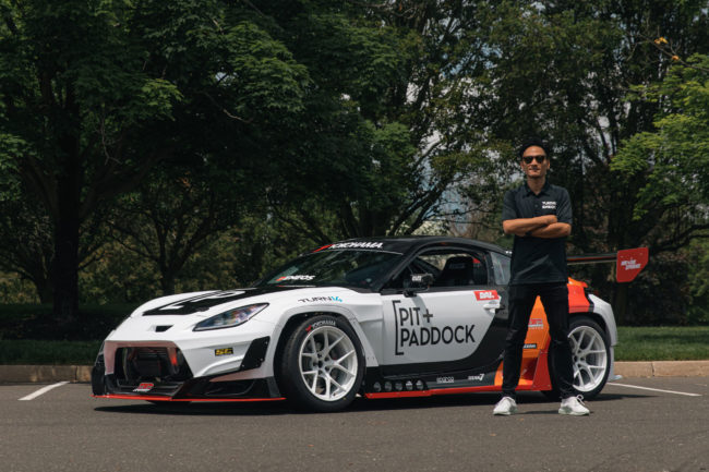 Dai Yoshihara Standing with Pit Paddock Subaru Car