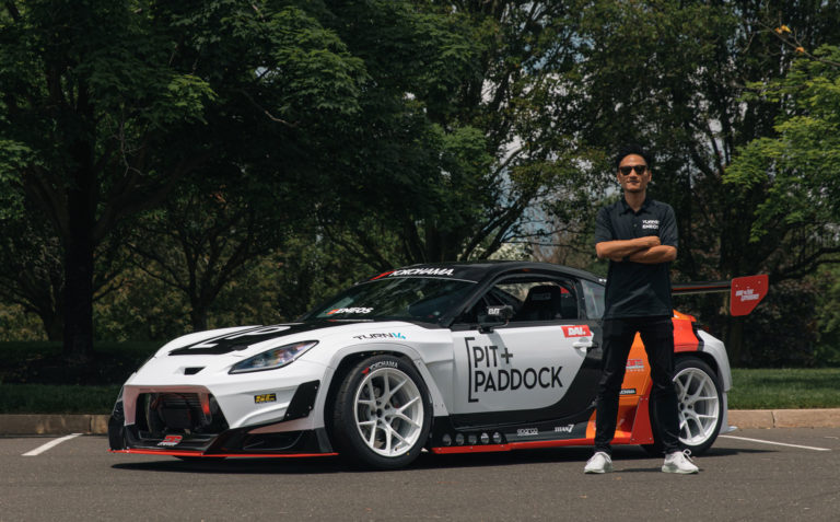 Dai Yoshihara Standing with Pit Paddock Subaru Car