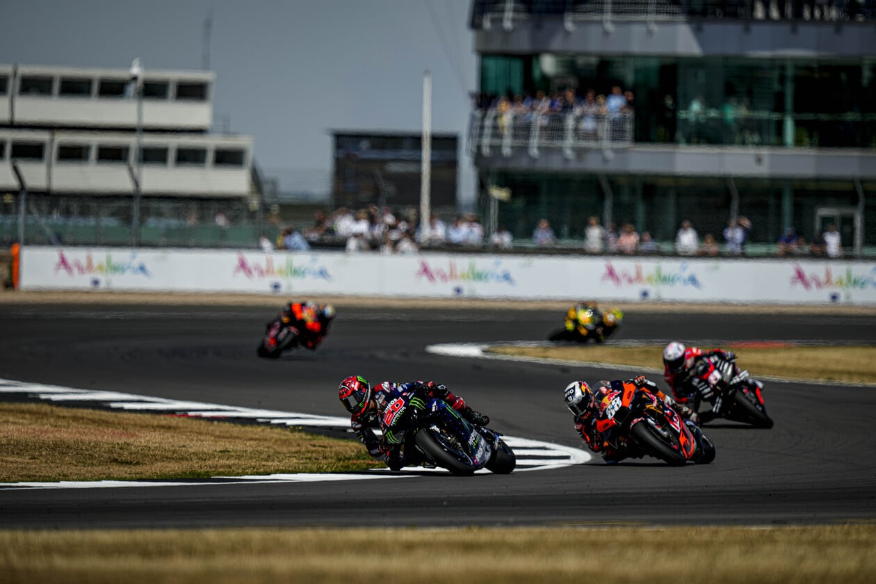 Multiple MotoGP racers making a turn Multiple MotoGP racers making a turn